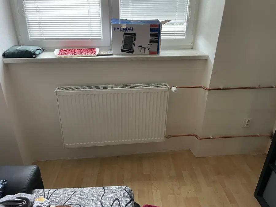 Deskový radiátor s novým měděným rozvodem vedeným po stěně
