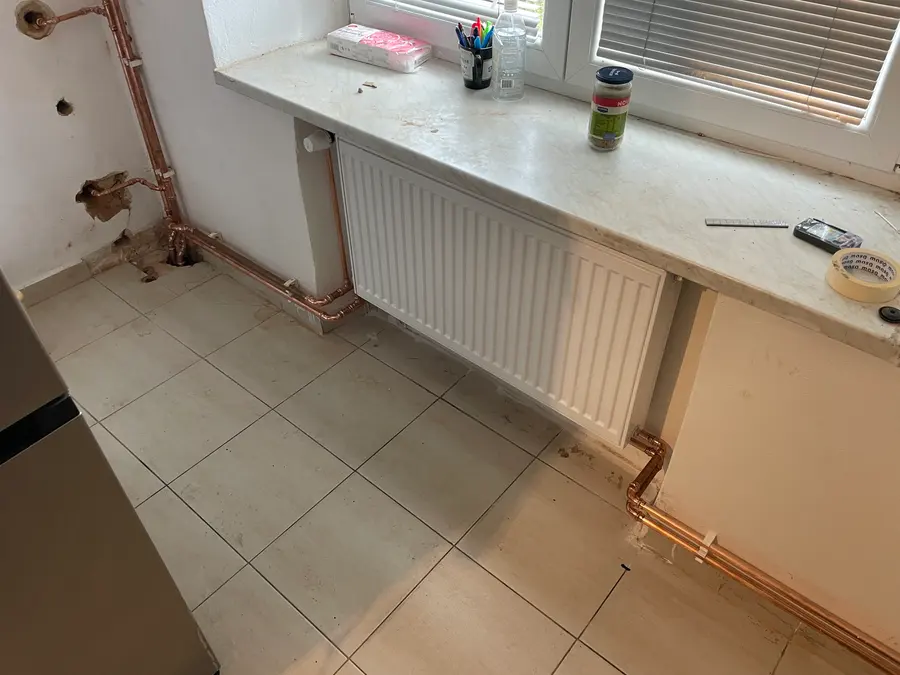 Dlouhý deskový radiátor pod oknem s napojením
